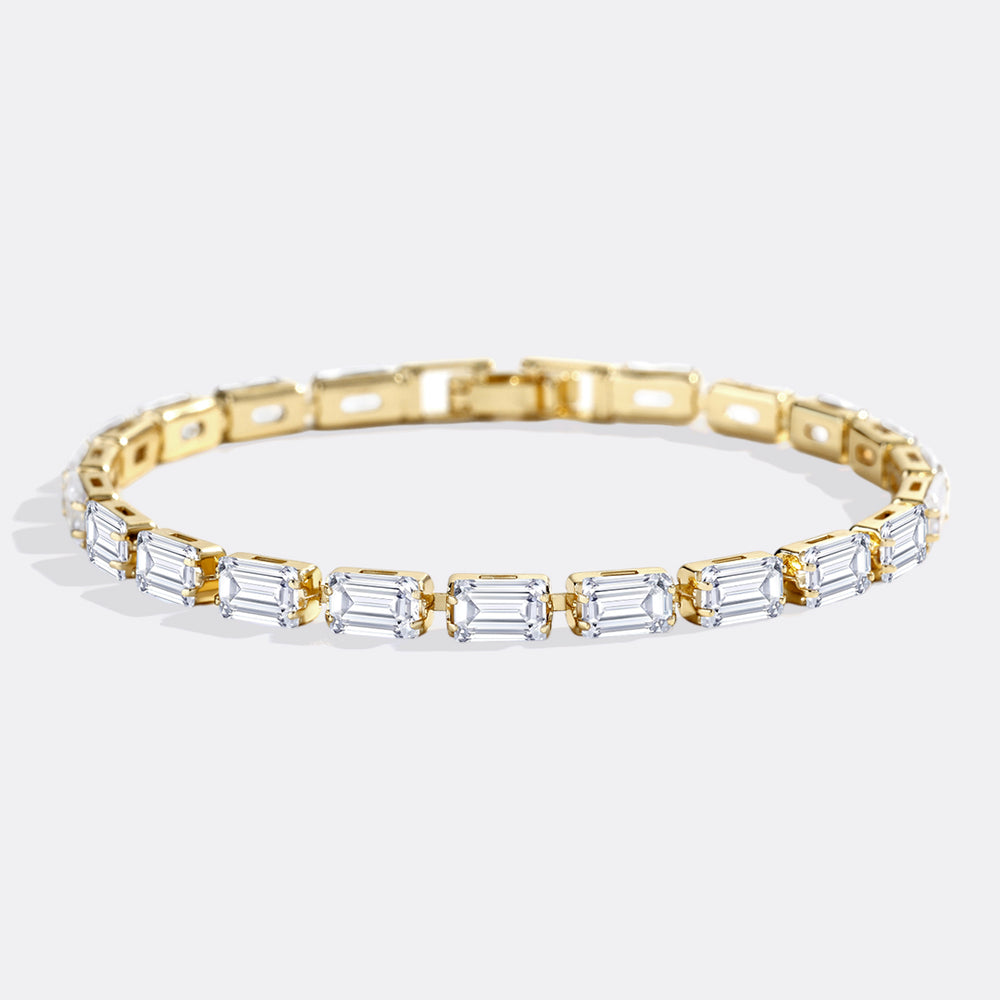 Gold bracelet with baguette-shaped diamonds on a white background