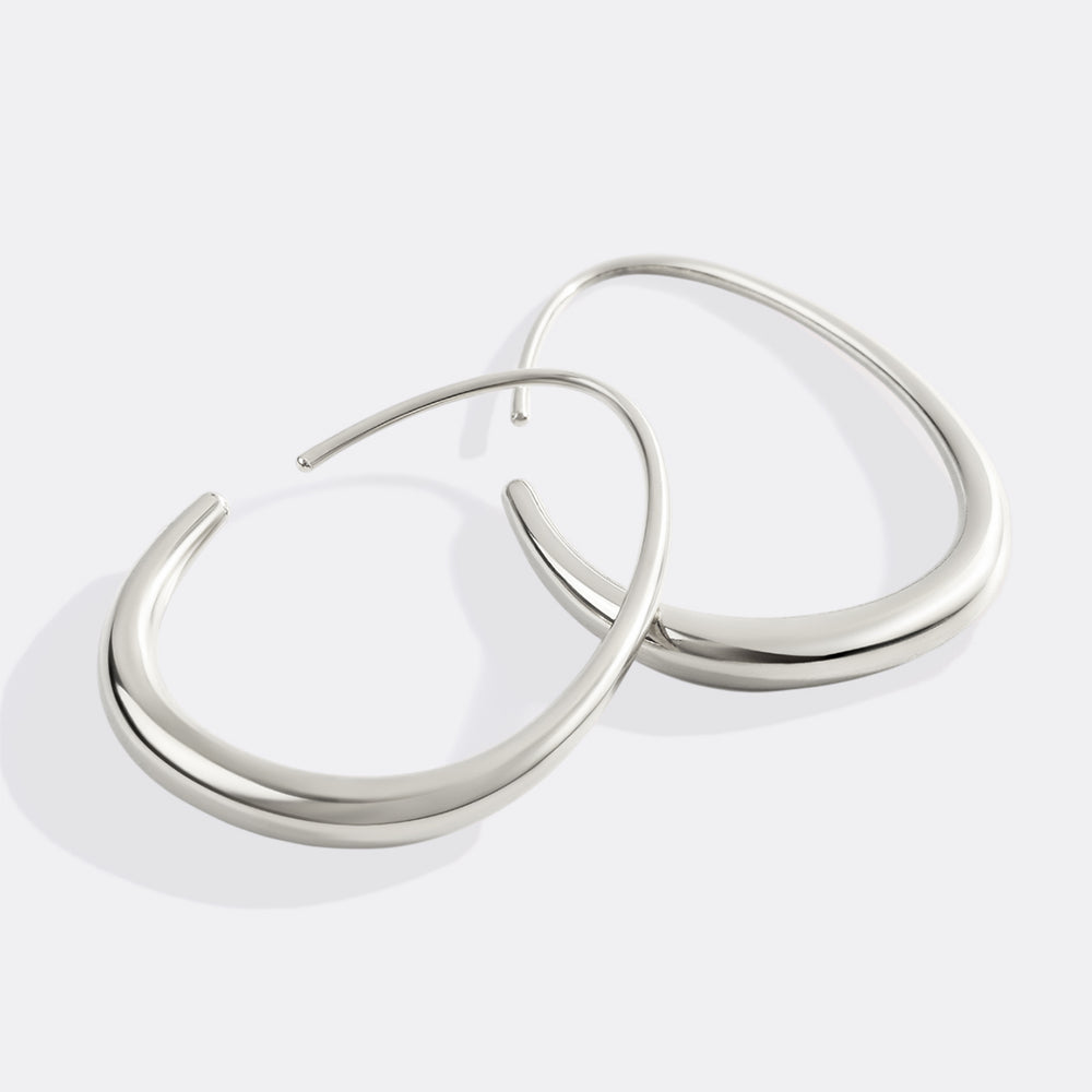 Pair of silver hoop earrings on a light gray background