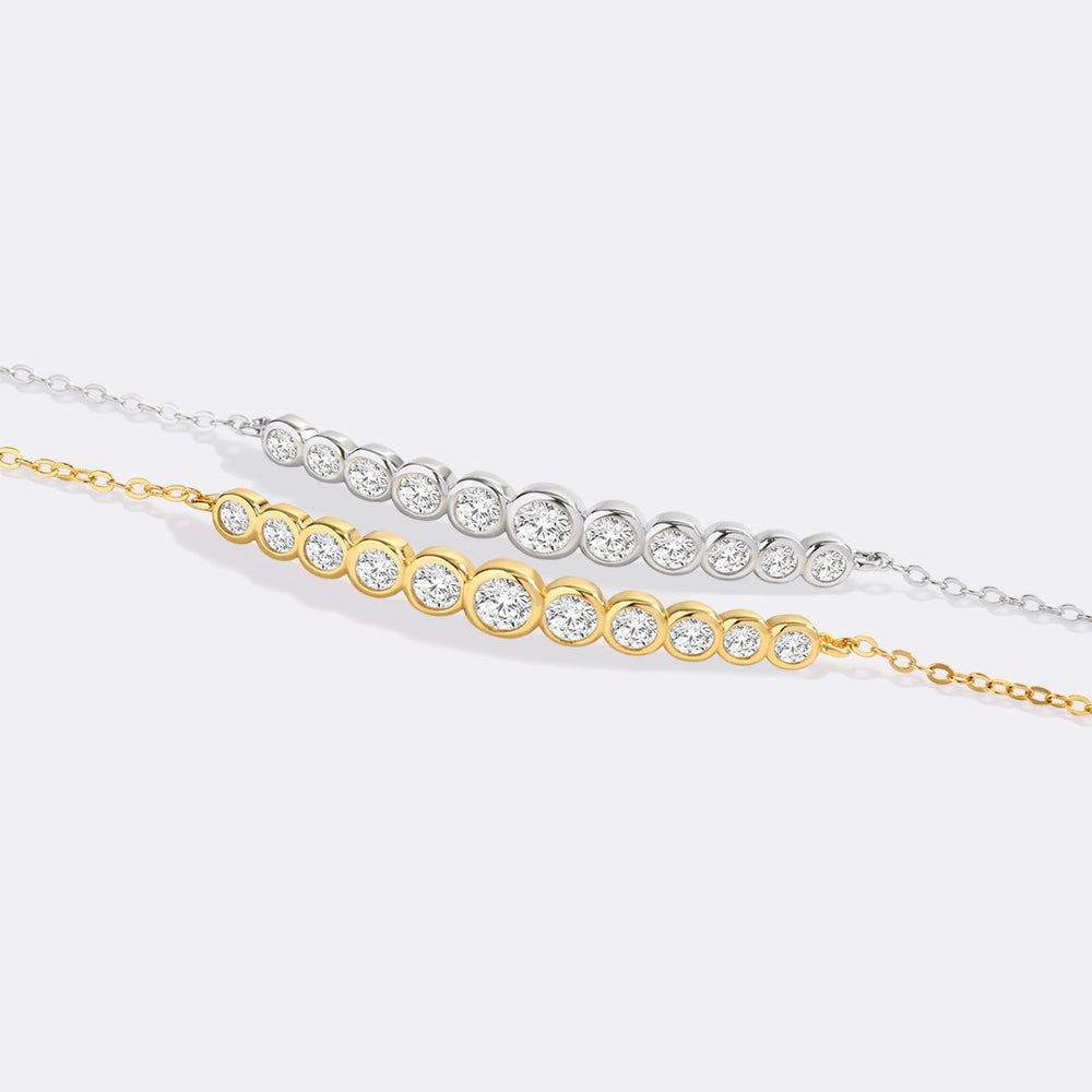 Two diamond bracelets, one gold and one silver, on a light gray background.