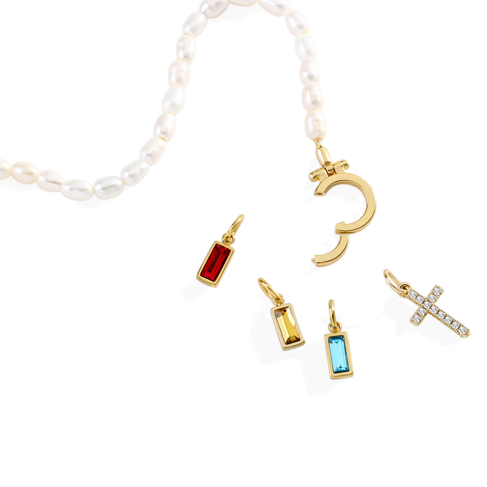 Gold charm bracelet with various charms on a white background