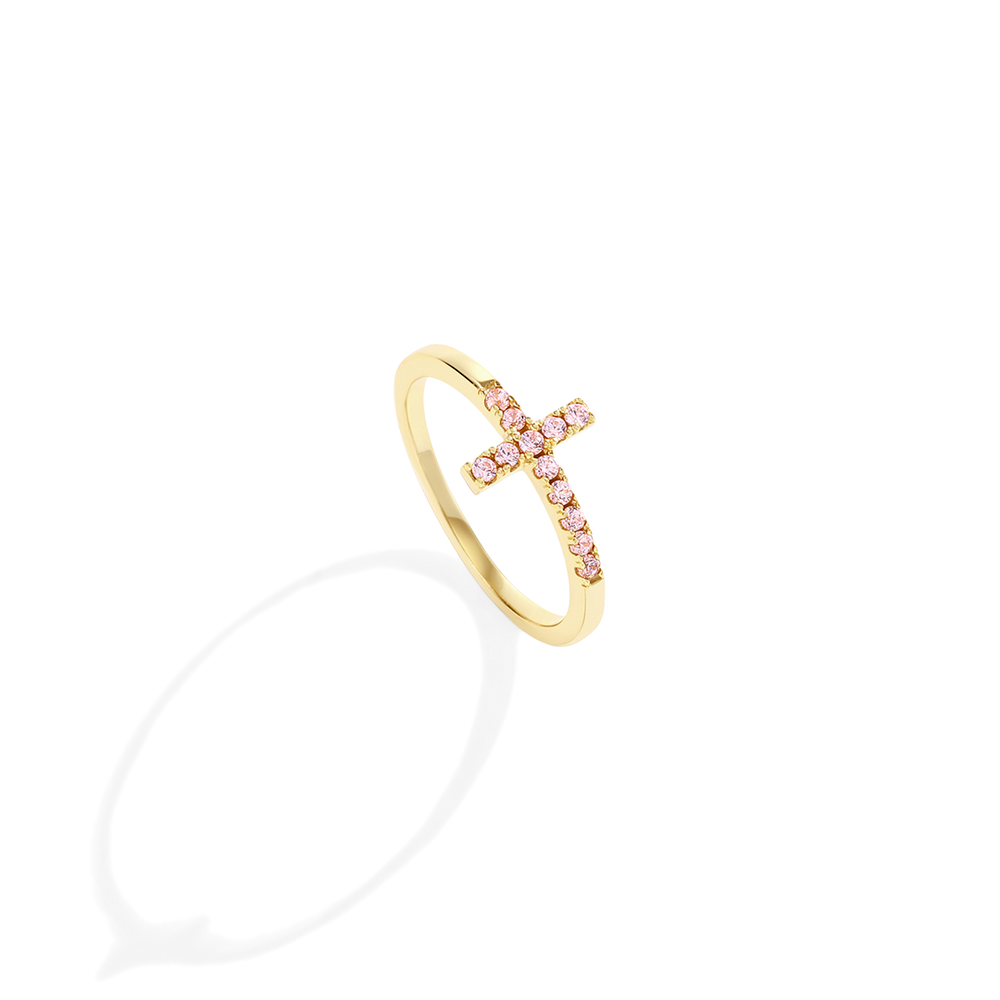 Gold ring with pink gemstones on a light gray background