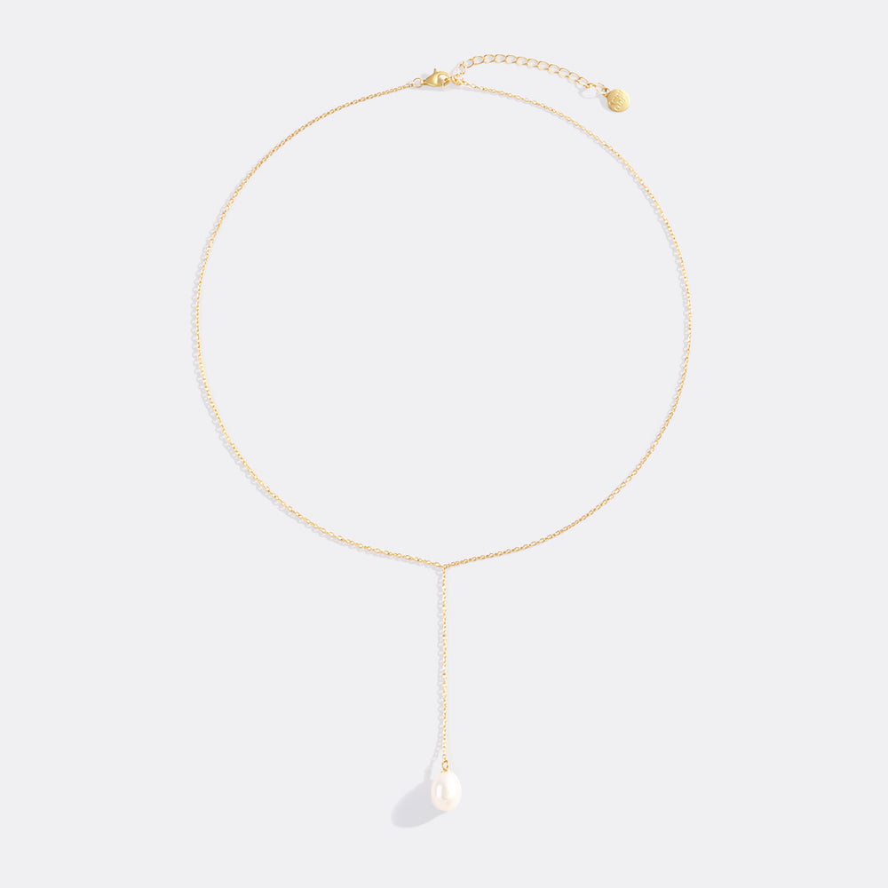 Gold necklace with a pearl pendant on a white background