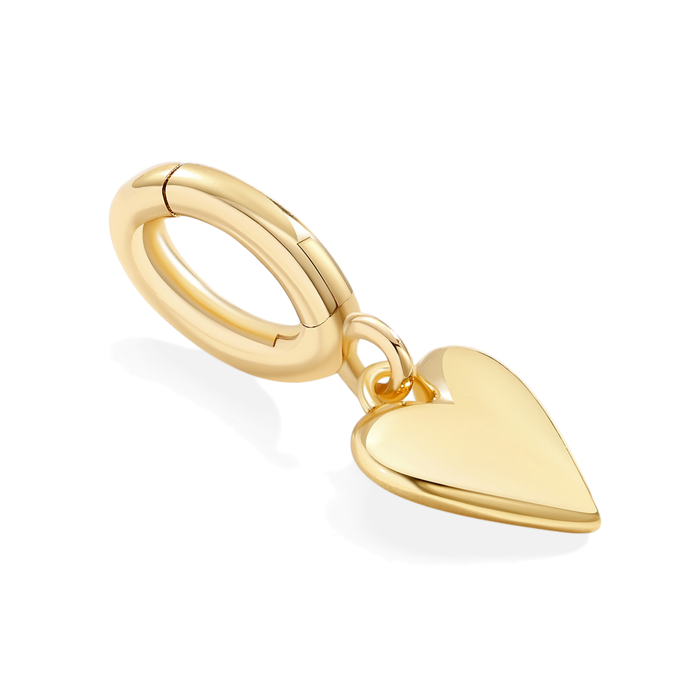 Gold ring with a heart-shaped pendant on a light gray background
