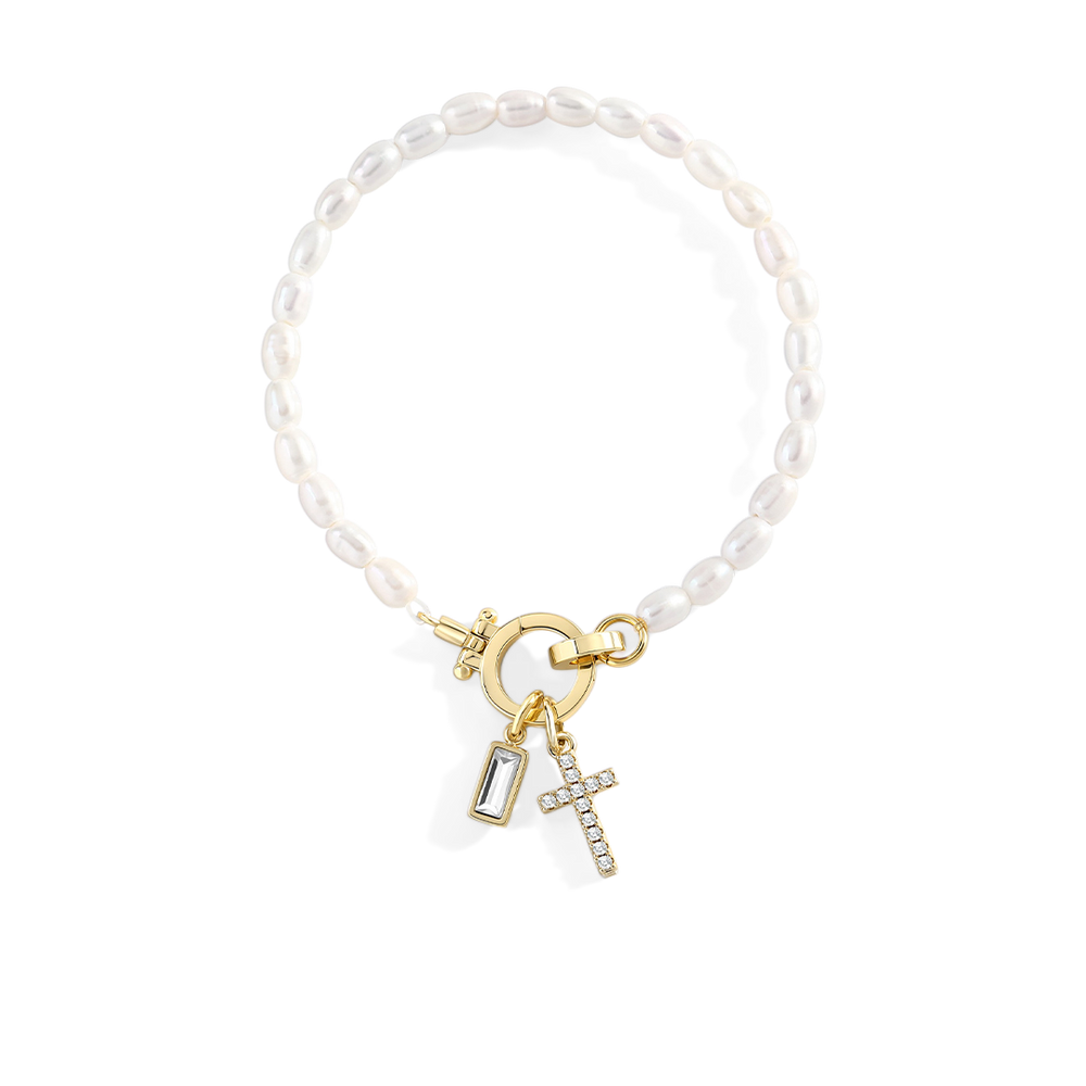 Pearl bracelet with gold charms on a light gray background