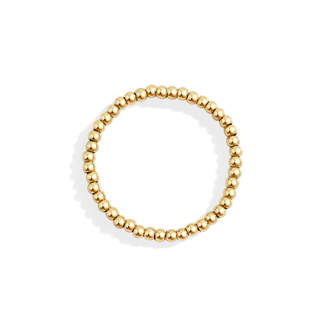 Gold beaded ring on a light gray background
