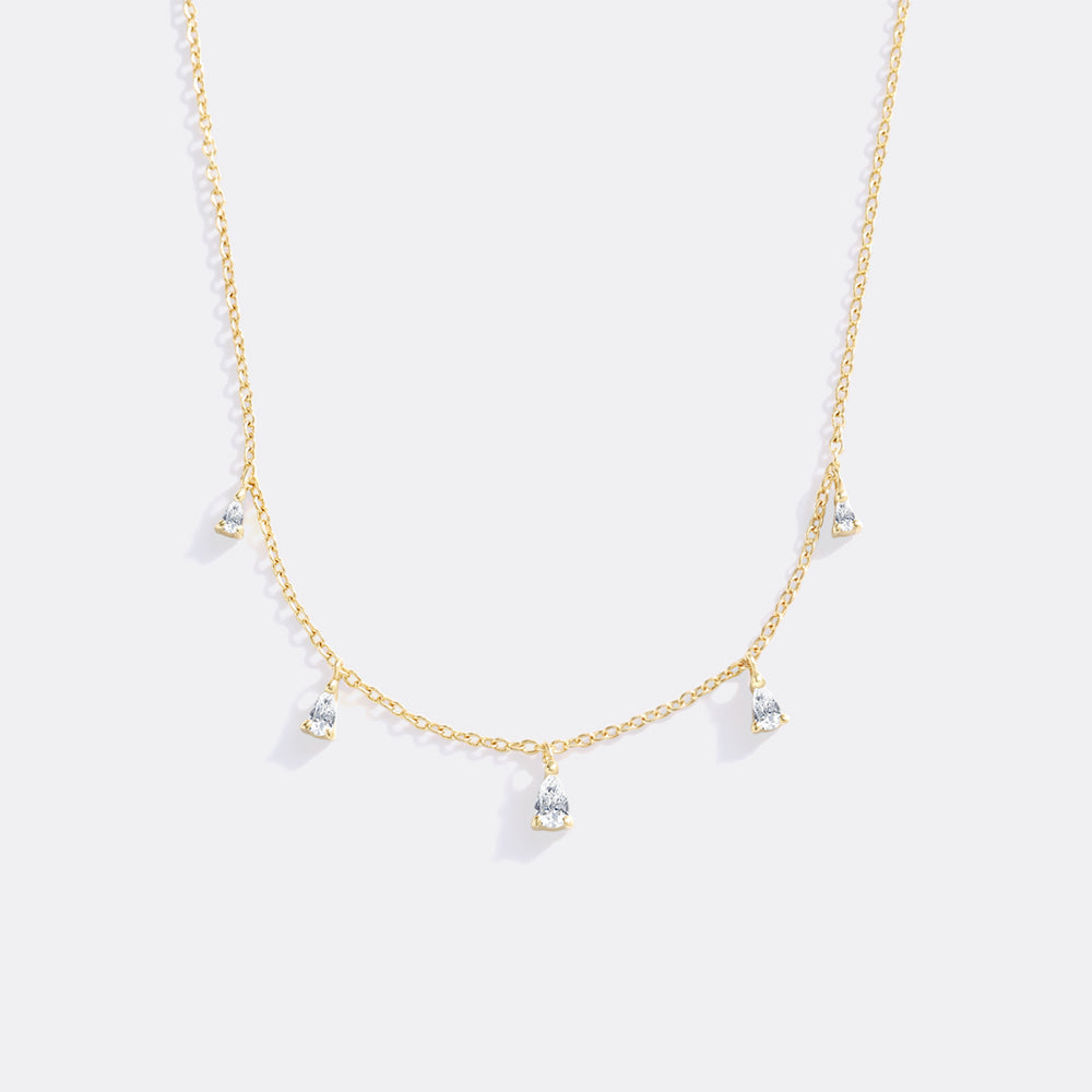 Gold necklace with small pendants on a white background