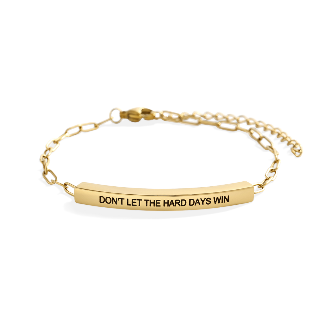 Gold bracelet with motivational message on a white background