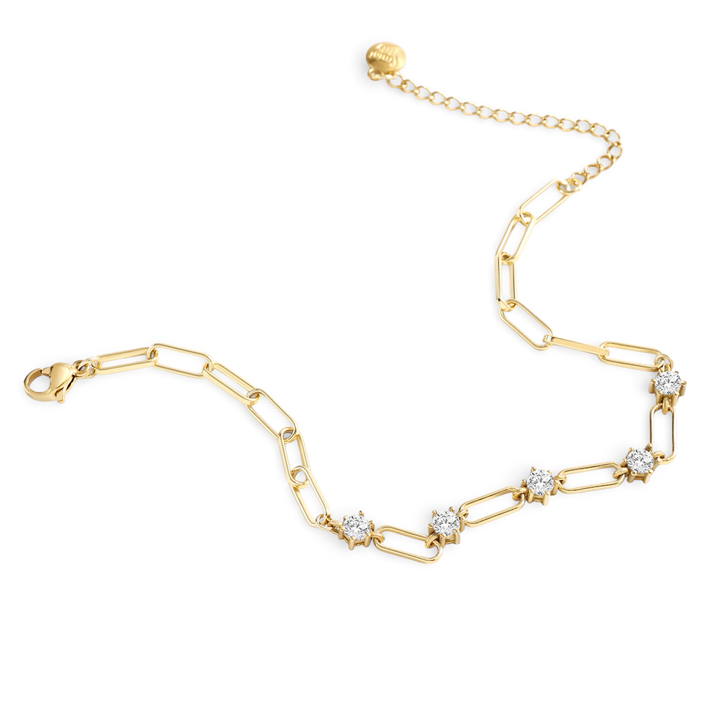 Gold bracelet with diamond-like stones on a light gray background