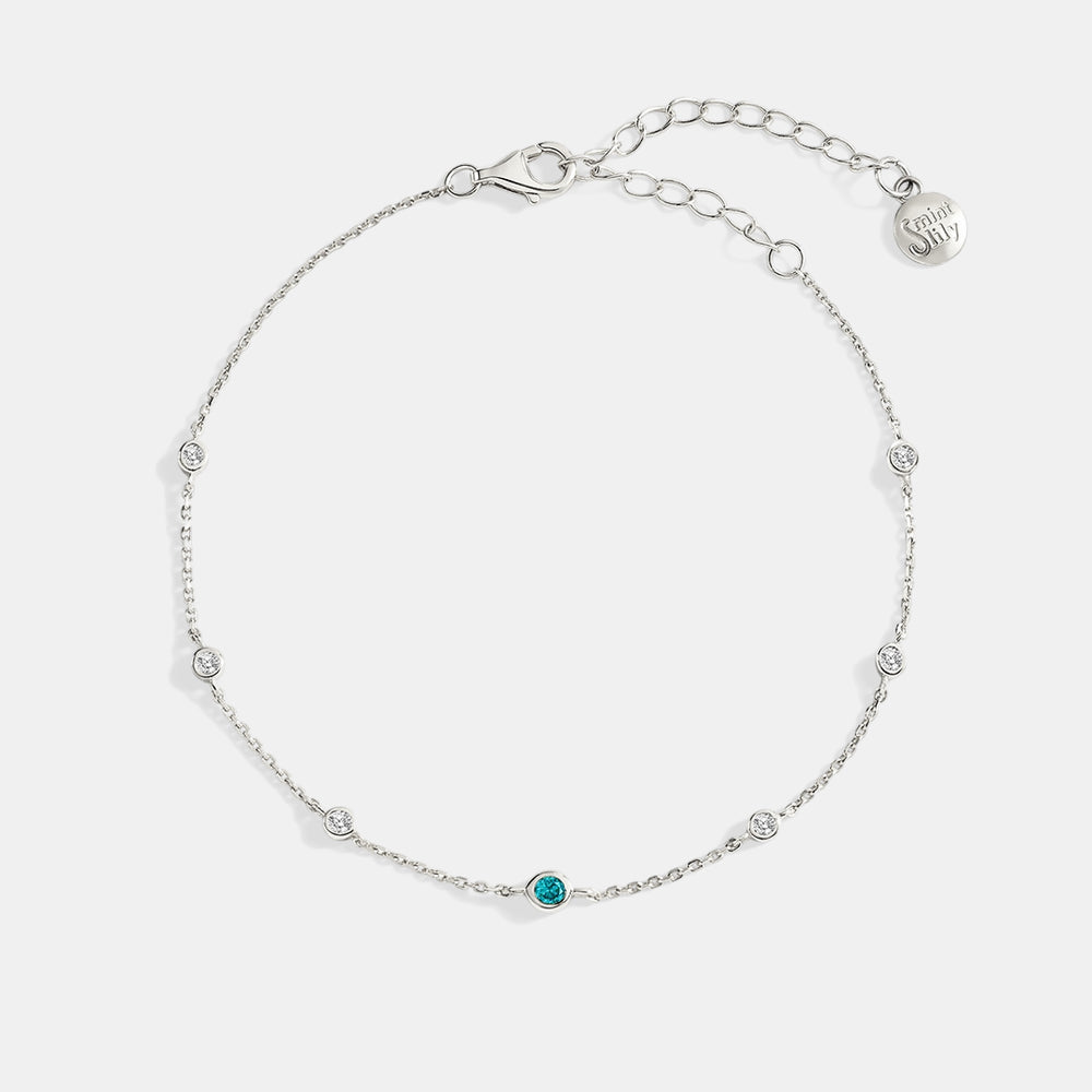 Silver bracelet with a blue gemstone on a white background