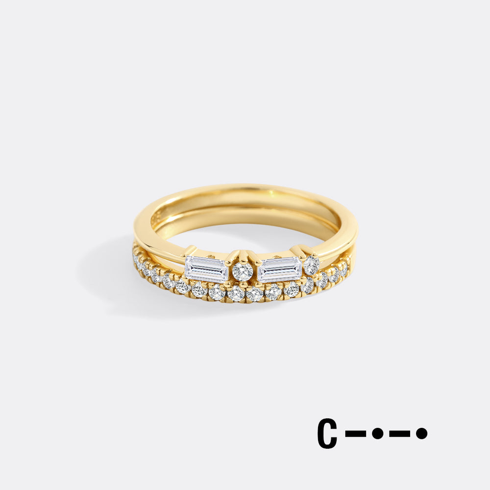 Gold ring with diamonds on a light gray background