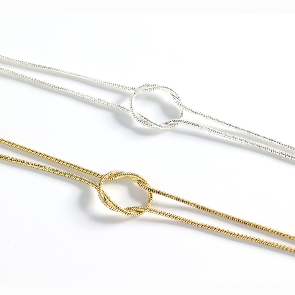 Two gold and silver necklaces on a white background