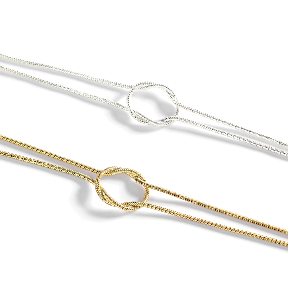 Two gold and silver necklaces on a white background