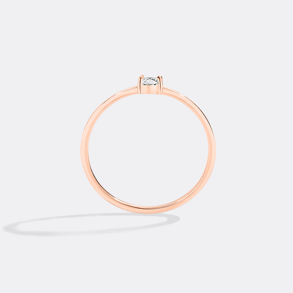 Rose gold ring with a diamond on a light gray background