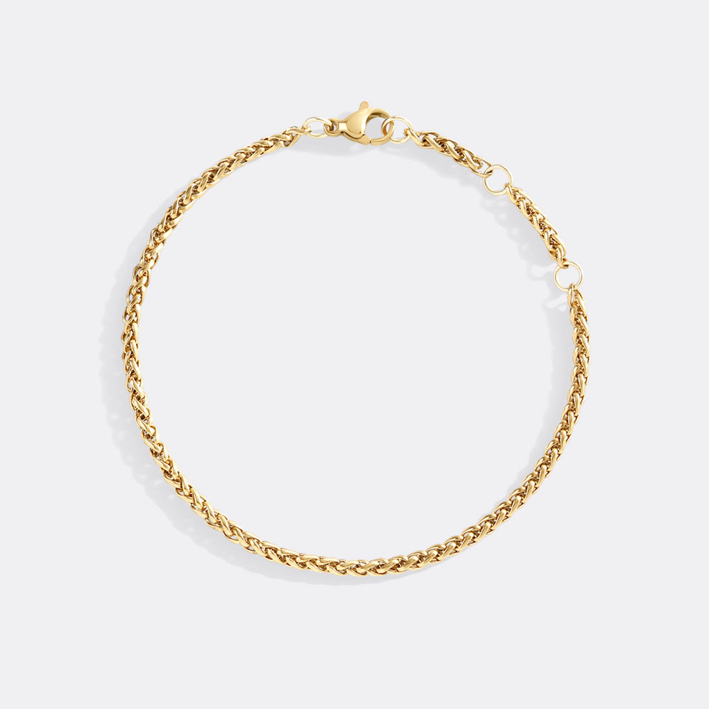 Gold chain bracelet on a light gray background