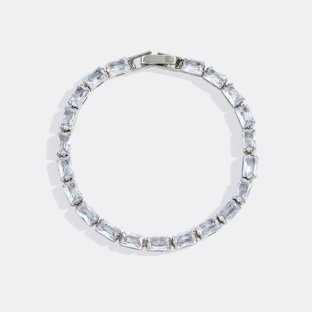 Silver bracelet with clear gemstones on a light gray background