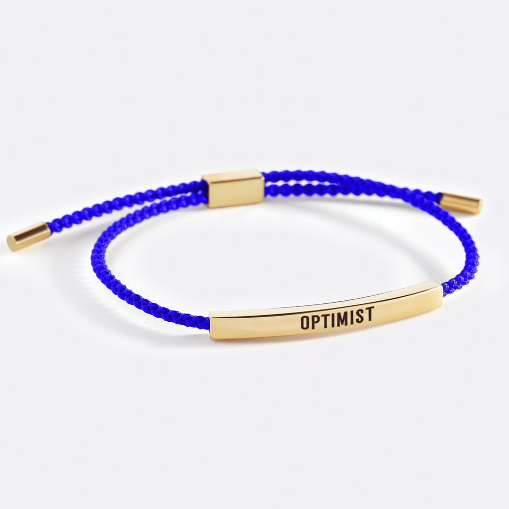 An inspirational tube bracelet with the word 'OPTIMIST' printed on it, displayed on a white background with the brand name 'optimist' above.