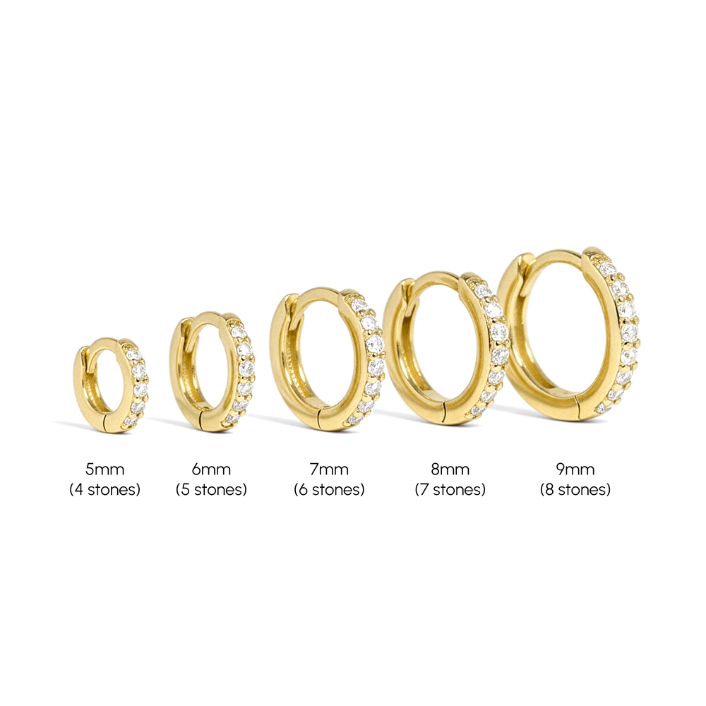 Set of gold hoop earrings with varying sizes on a white background