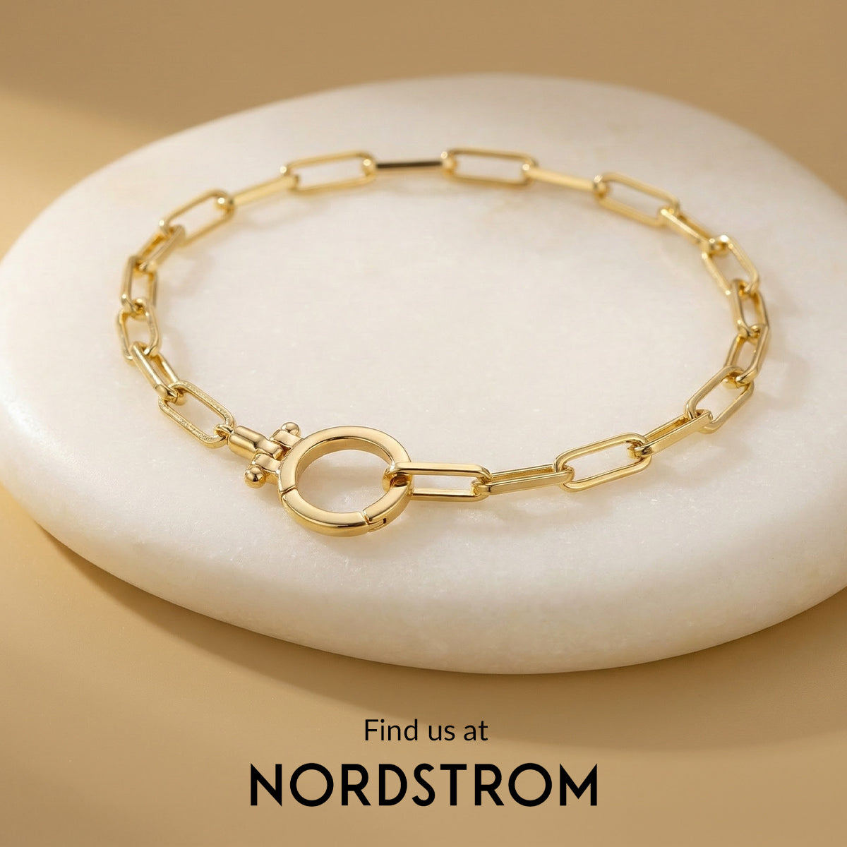 Gold chain bracelet on a white stone with 'Nordstrom' branding.