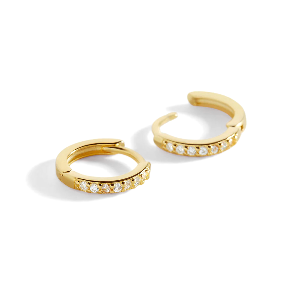 Gold hoop earrings with embedded stones on a light gray background