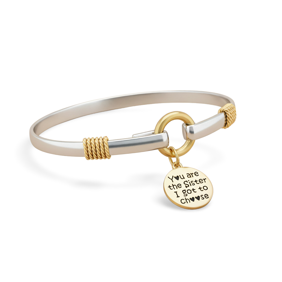 Bracelet with gold and silver design and a charm on a white background