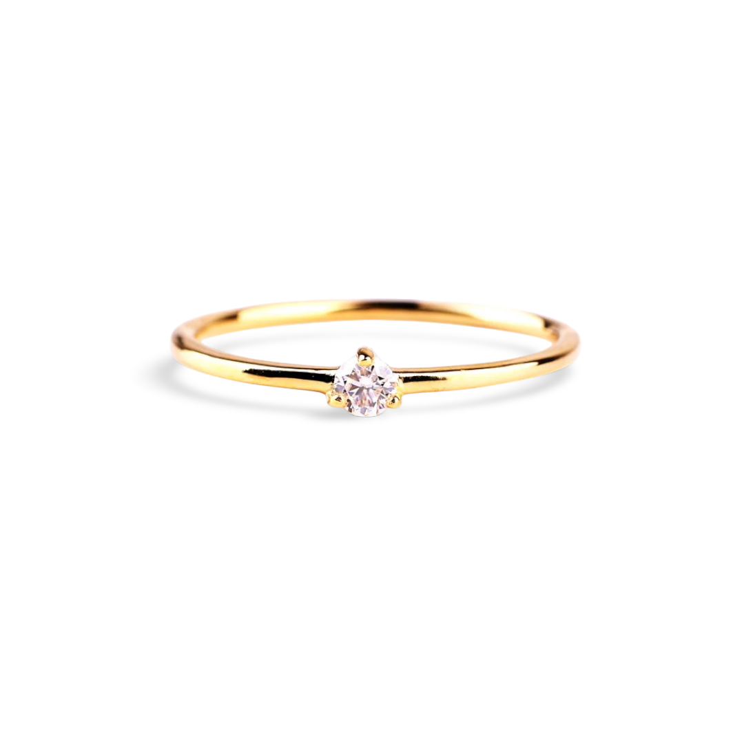 Gold ring with a small diamond on a light gray background