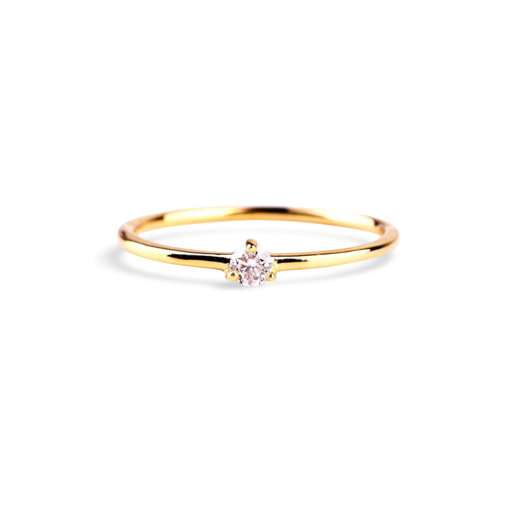 Gold ring with a small diamond on a light gray background