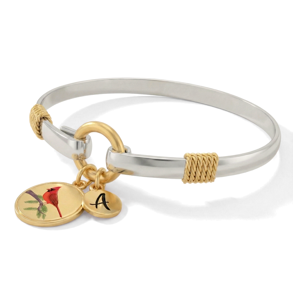 Silver bangle with gold accents and charms on a white background