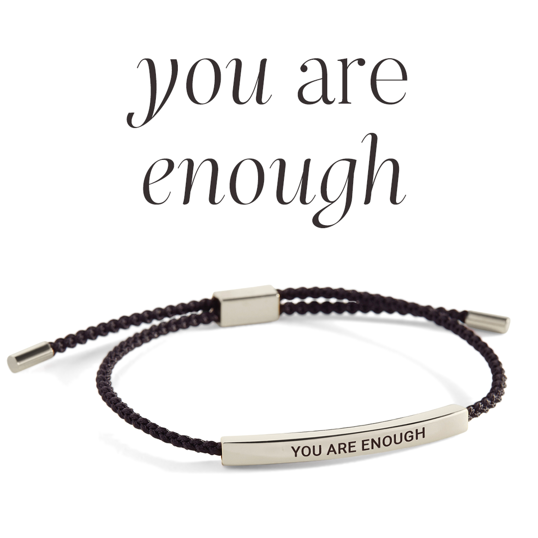 Bracelet with 'YOU ARE ENOUGH' engraving on a light gray background